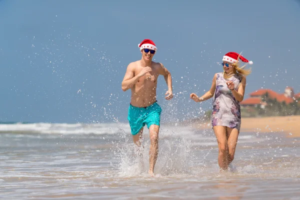 Noel çift sahilde kum üzerinde çalışan rahatlatıcı mutlu — Stok fotoğraf