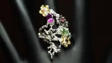 Gümüş yüzük ve siyah el üzerinde doğal değerli taşlar.