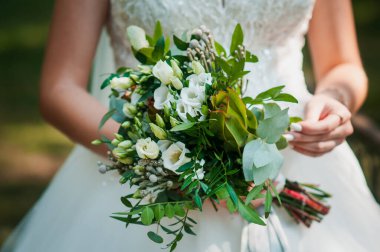 Gelinin elinde bir buket çiçek