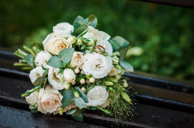 Beyaz güllü bir bukette altın alyanslar