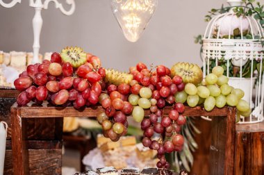 Düğün ziyafetinde meyve dilimleme. Karpuz, üzüm, çilek, portakal, erik, armut, dinha, şeftali, kivi, ananas, hurma, elma