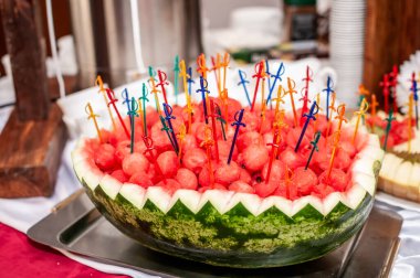 Düğün ziyafetinde meyve dilimleme. Karpuz, üzüm, çilek, portakal, erik, armut, dinha, şeftali, kivi, ananas, hurma, elma