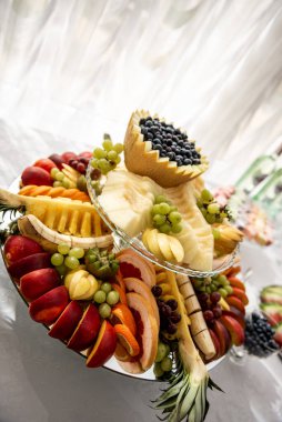 Düğün ziyafetinde meyve dilimleme. Karpuz, üzüm, çilek, portakal, erik, armut, dinha, şeftali, kivi, ananas, hurma, elma
