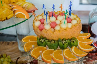 Düğün ziyafetinde meyve dilimleme. Karpuz, üzüm, çilek, portakal, erik, armut, dinha, şeftali, kivi, ananas, hurma, elma