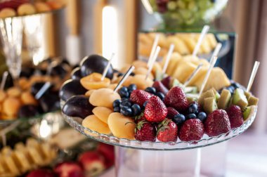 Düğün ziyafetinde meyve dilimleme. Karpuz, üzüm, çilek, portakal, erik, armut, dinha, şeftali, kivi, ananas, hurma, elma