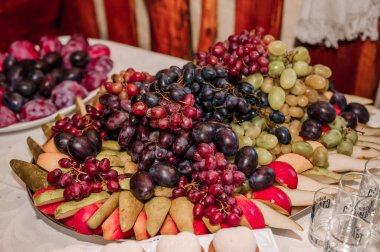 Düğün ziyafetinde meyve dilimleme. Karpuz, üzüm, çilek, portakal, erik, armut, dinha, şeftali, kivi, ananas, hurma, elma