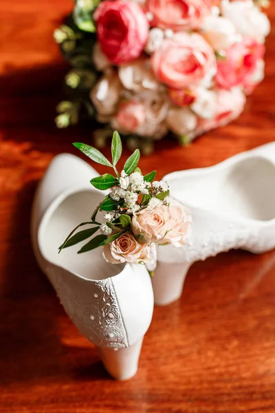 Bridal accessories. White shoes, bridal bouquet, boutonniere