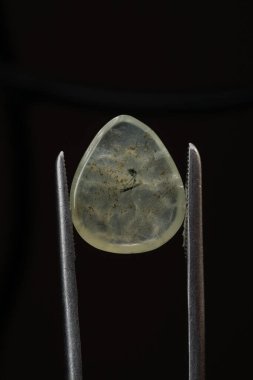 Siyah bir arkaplanda cımbızla doğal bir kavrayış taşı