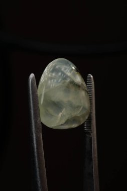 Siyah bir arkaplanda cımbızla doğal bir kavrayış taşı