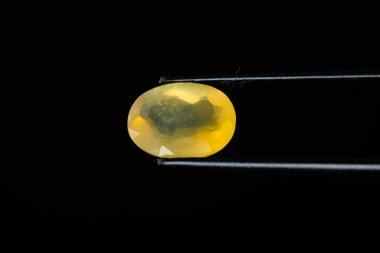 Siyah arka planda cımbızla sarı opal