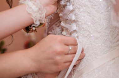 Gelinliğin arkası, nedime elleri gelinliği bağlayan