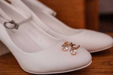 Gelin için düğün aksesuarları. Ayakkabılar, küpeler, jartiyer, parfüm