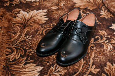 Yerde siyah ayakkabılarda altın alyanslar. Düğün günü damat için aksesuarlar.