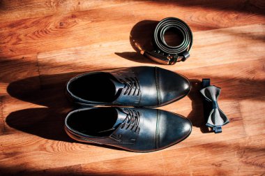 Mavi deri erkek ayakkabısı, papyon ve kemer yere yatar. Damat aksesuarları.