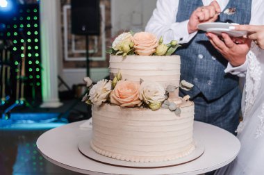 Yeni evliler düğün pastasını kesti. Düğündeki gelin ve damat düğün pastası kestiler.