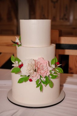 Çiçeklerle süslenmiş güzel düğün pastası, yakın plan ve bulanık arkaplan