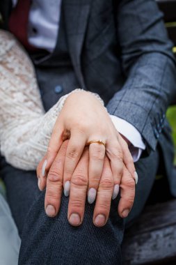 Gelin damadın elini tutuyor.