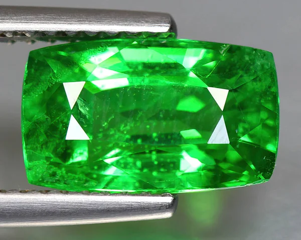 Natural gemstone green tsavorite garnet on background