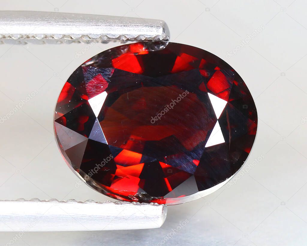 Natural gemstone red zircon on gray background