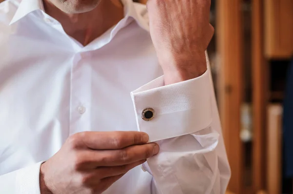男はシャツの袖にカフスボタンを固定している 新郎はシャツの袖にボタンを固定します — ストック写真