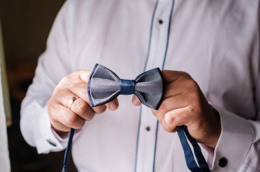 Mavi papyon damadın elinde. Bir adamın elinde papyon