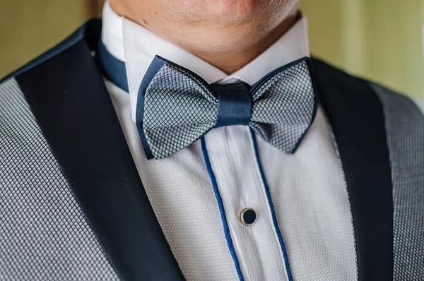 Blue bow tie around the neck of a man
