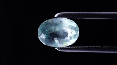 Arka plandaki cımbızda doğal akuamarin.