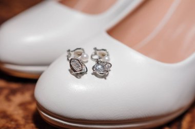 Gelin için düğün aksesuarları. Beyaz ayakkabılar, küpeler
