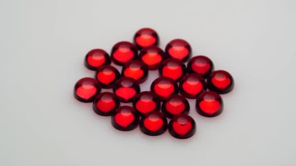 回転テーブルの上の白い背景にある天然の赤いガーネットの宝石 — ストック動画