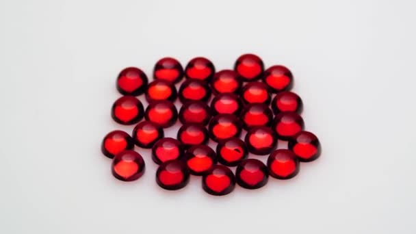 回転テーブルの上の白い背景にある天然の赤いガーネットの宝石 — ストック動画