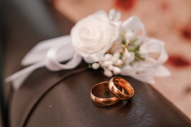 Bir çift alyans ve beyaz çiçekli buket.