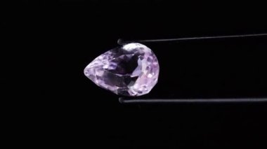 Doğal pembe kunzite mücevheri sehpanın üzerinde cımbızla