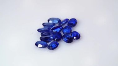 Dönüş masasının beyaz zemininde doğal kyanit mücevheri