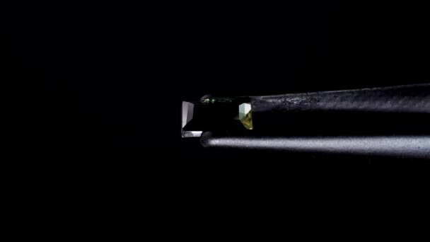 转盘桌上的镊子里有天然绿色的可罗地平宝石 — 图库视频影像