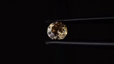 Sehpanın üzerinde cımbızla Moissanite mücevheri