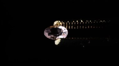 Sehpanın üzerinde cımbızla doğal morganit mücevheri