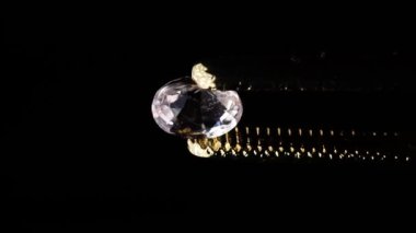 Sehpanın üzerinde cımbızla doğal morganit mücevheri