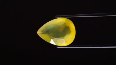 Arka plandaki cımbızda doğal opal değerli taş