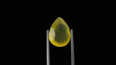 Arka plandaki cımbızda doğal opal değerli taş