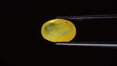 Arka plandaki cımbızda doğal opal değerli taş