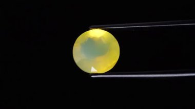 Arka plandaki cımbızda doğal opal değerli taş