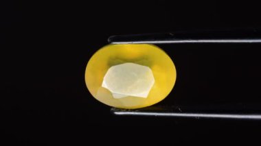 Arka plandaki cımbızda doğal opal değerli taş