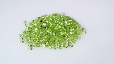 Dönüş masasının beyaz zemininde doğal peridot taşı