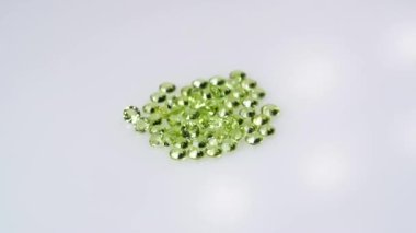 Dönüş masasının beyaz zemininde doğal peridot taşı