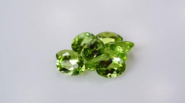 Dönüş masasının beyaz zemininde doğal peridot taşı