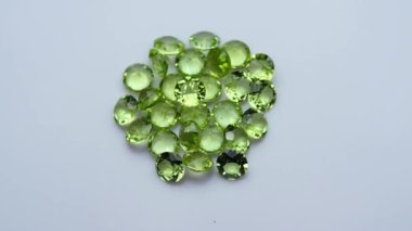 Dönüş masasının beyaz zemininde doğal peridot taşı