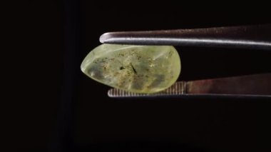 Arka plandaki cımbızda doğal yeşil taş var.