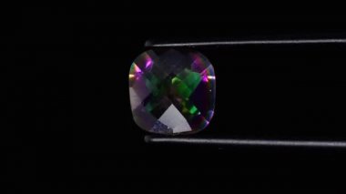 Dönen masanın üzerinde cımbızla doğal gökkuşağı kuvars taşı