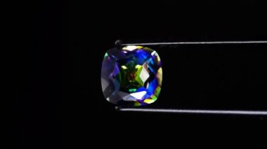 Dönen masanın üzerinde cımbızla doğal gökkuşağı kuvars taşı