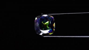 Dönen masanın üzerinde cımbızla doğal gökkuşağı kuvars taşı